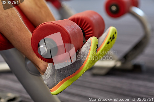 Image of close up of man legs exercising on gym machine