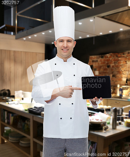 Image of happy male chef cook showing tablet pc