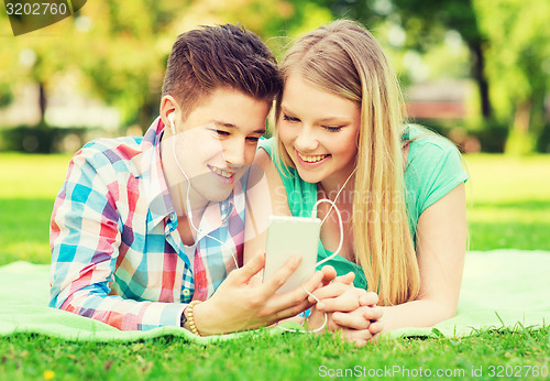 Image of smiling couple with smartphone and earphones
