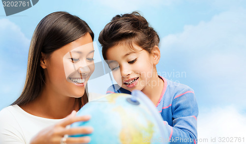 Image of happy mother and daughter with globe