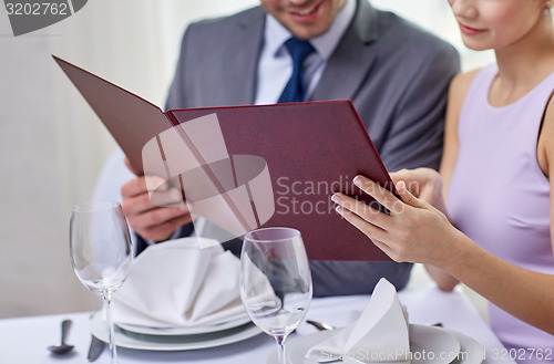 Image of close up of happy couple with menu at restaurant