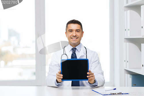 Image of smiling male doctor showing tablet pc blank screen