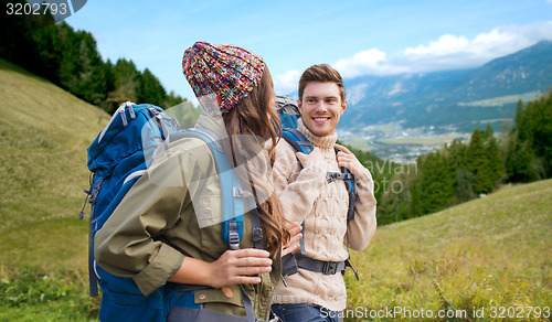 Image of smiling couple with backpacks hiking