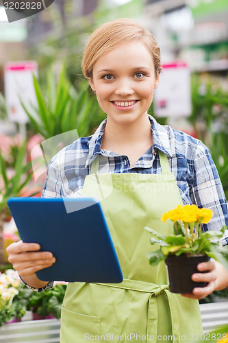 Image of happy woman with tablet pc in greenhouse