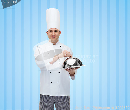 Image of happy male chef cook holding cloche