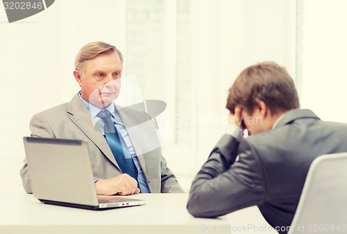 Image of older man and young man having argument in office