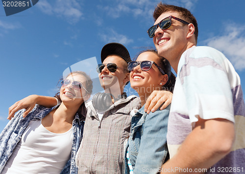 Image of smiling teenagers in sunglasses hanging outside