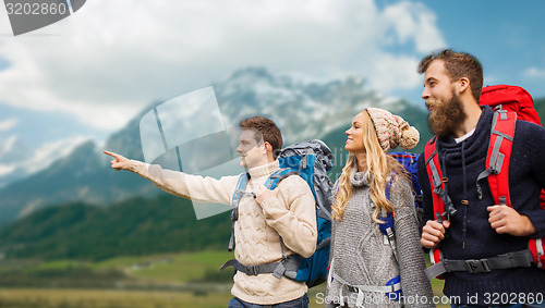 Image of group of smiling friends with backpacks hiking