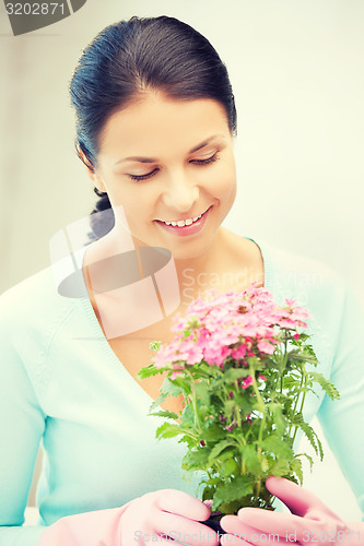 Image of lovely housewife with flower in pot