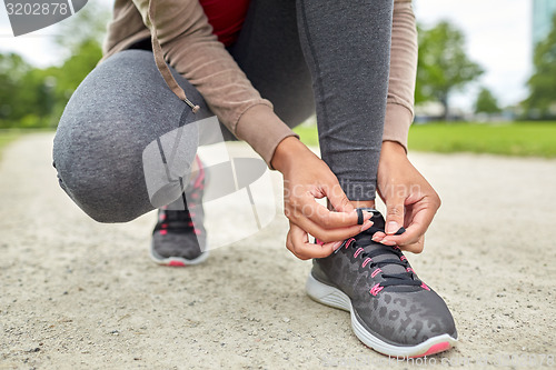 Image of close up of woman tying shoelaces outdoors