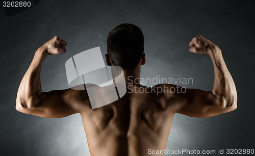 Image of young man showing biceps