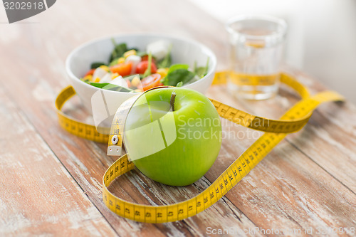 Image of close up of green apple and measuring tape