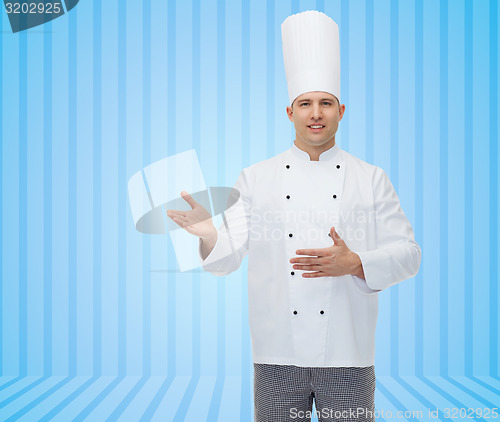 Image of happy male chef cook inviting