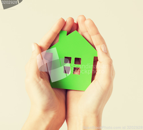 Image of hands holding green house