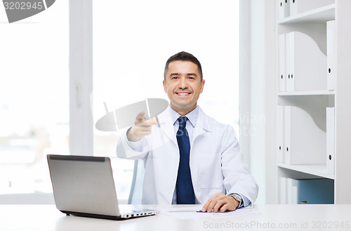 Image of smiling doctor pointing finger at you in office