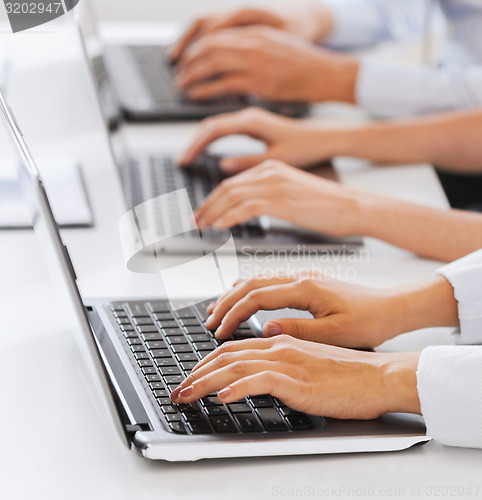 Image of group of people working with laptops in office