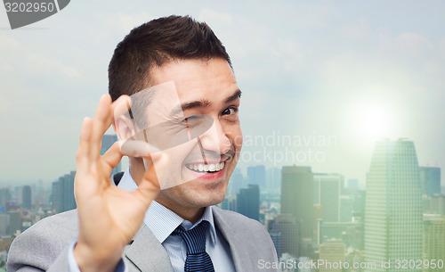 Image of happy businessman in suit showing ok hand sign