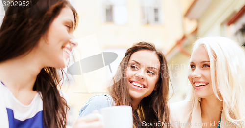 Image of beautiful girls drinking coffee in cafe