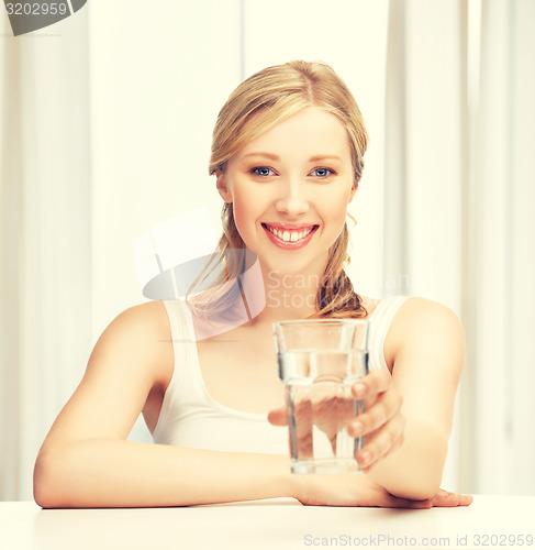 Image of young smiling woman with glass of water
