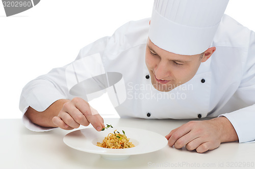 Image of happy male chef cook decorating dish