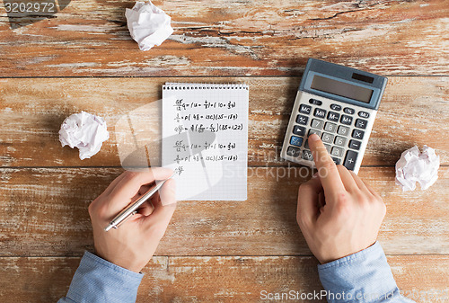 Image of close up of hands with calculator solving task