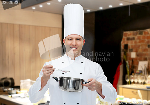 Image of happy male chef cook with pot and spoon