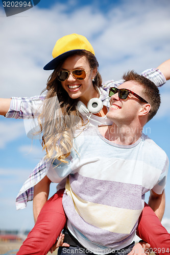 Image of smiling teenagers in sunglasses having fun outside