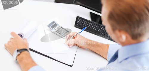 Image of businessman with notebook and calculator