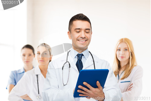 Image of smiling male doctor with tablet pc at hospital