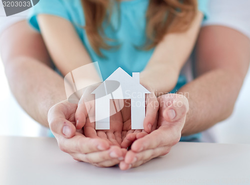 Image of close up of man and girl hands with paper house