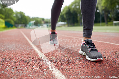 Image of close up of woman feet running on track from back