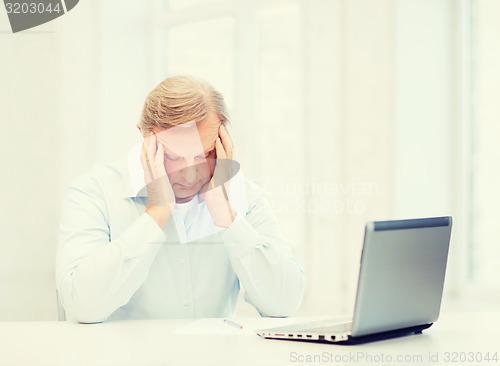 Image of stressed old man filling a form at home