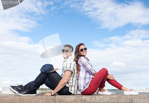 Image of teenagers sitting back to back