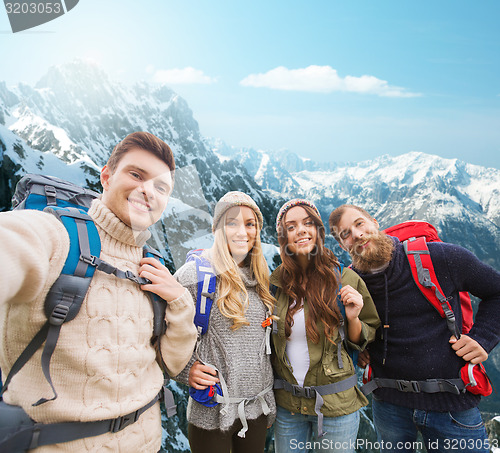 Image of group of smiling friends with backpacks hiking