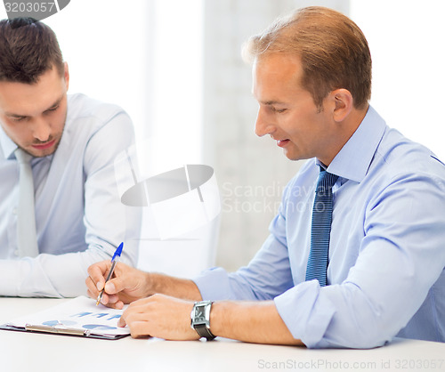 Image of businessmen with notebook on meeting