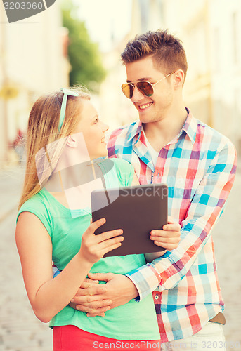 Image of smiling couple with tablet pc in city