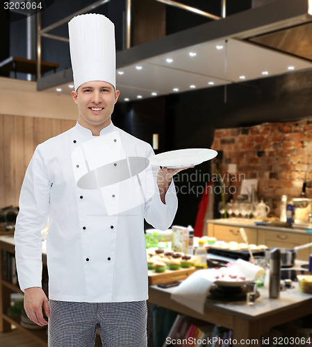 Image of happy male chef cook showing empty plate