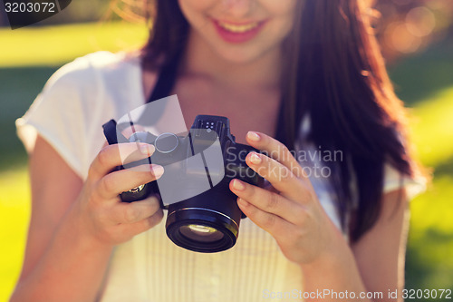 Image of close up of young girl with photo camera outdoors