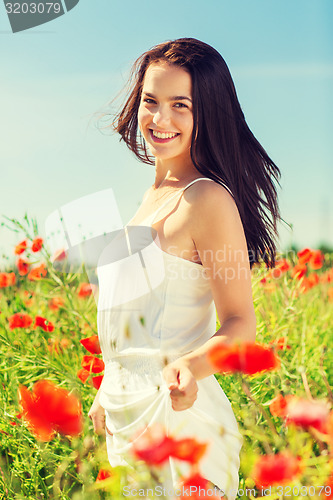 Image of smiling young woman on poppy field