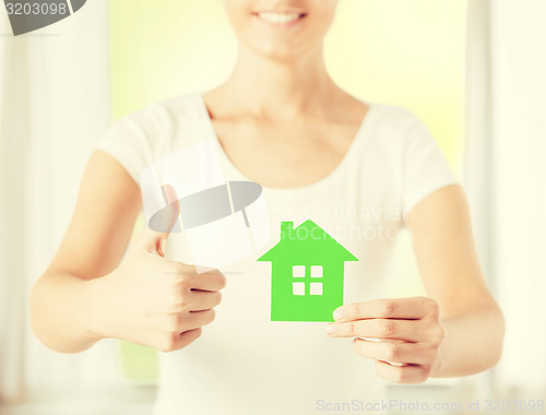 Image of woman hands holding green house