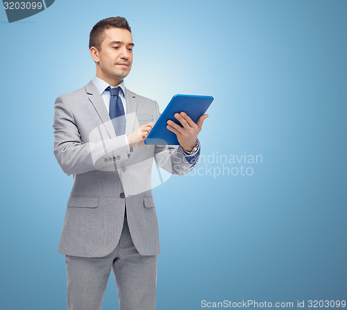 Image of happy businessman in suit holding tablet pc