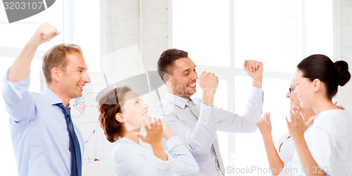 Image of business team celebrating victory in office