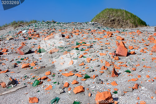 Image of beach with shards of glass and brick