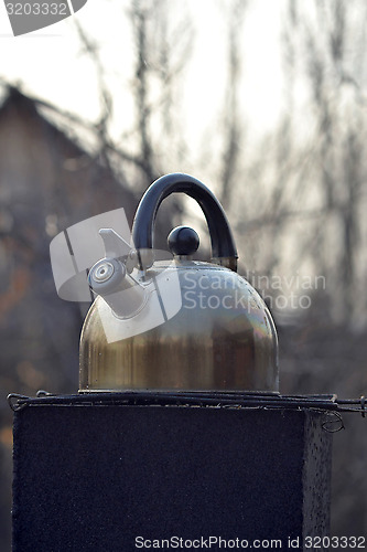 Image of the whistling kettle begins to boil on a brazier.