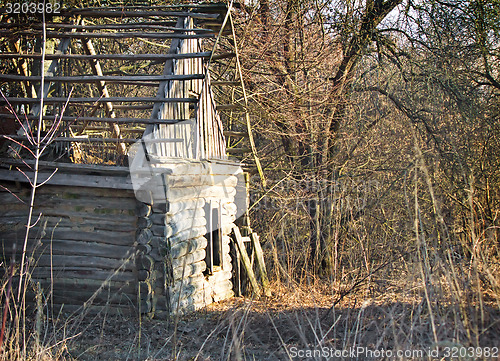 Image of Abandoned and ruined house in an overgrown forest .