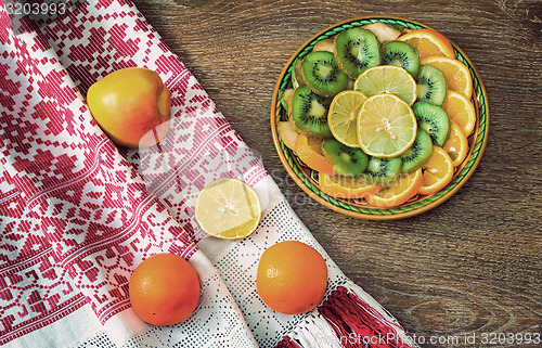 Image of Fruits and beautiful old towel on the table surface.