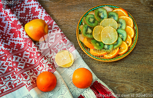 Image of Fruits and beautiful old towel on the table surface.