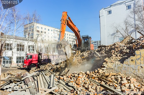 Image of Excavator loads garbage from demolished house