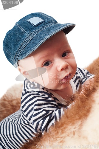 Image of Portrait of adorable child in hat lying on fur