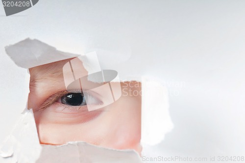 Image of Cute baby boy looking through paper hole 